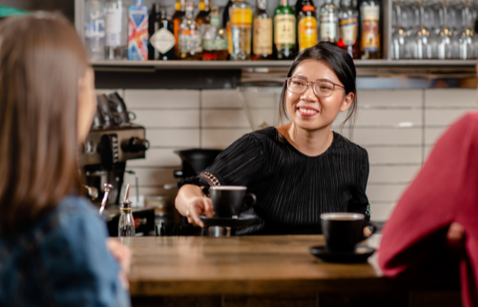 International student serving coffee in Adelaide